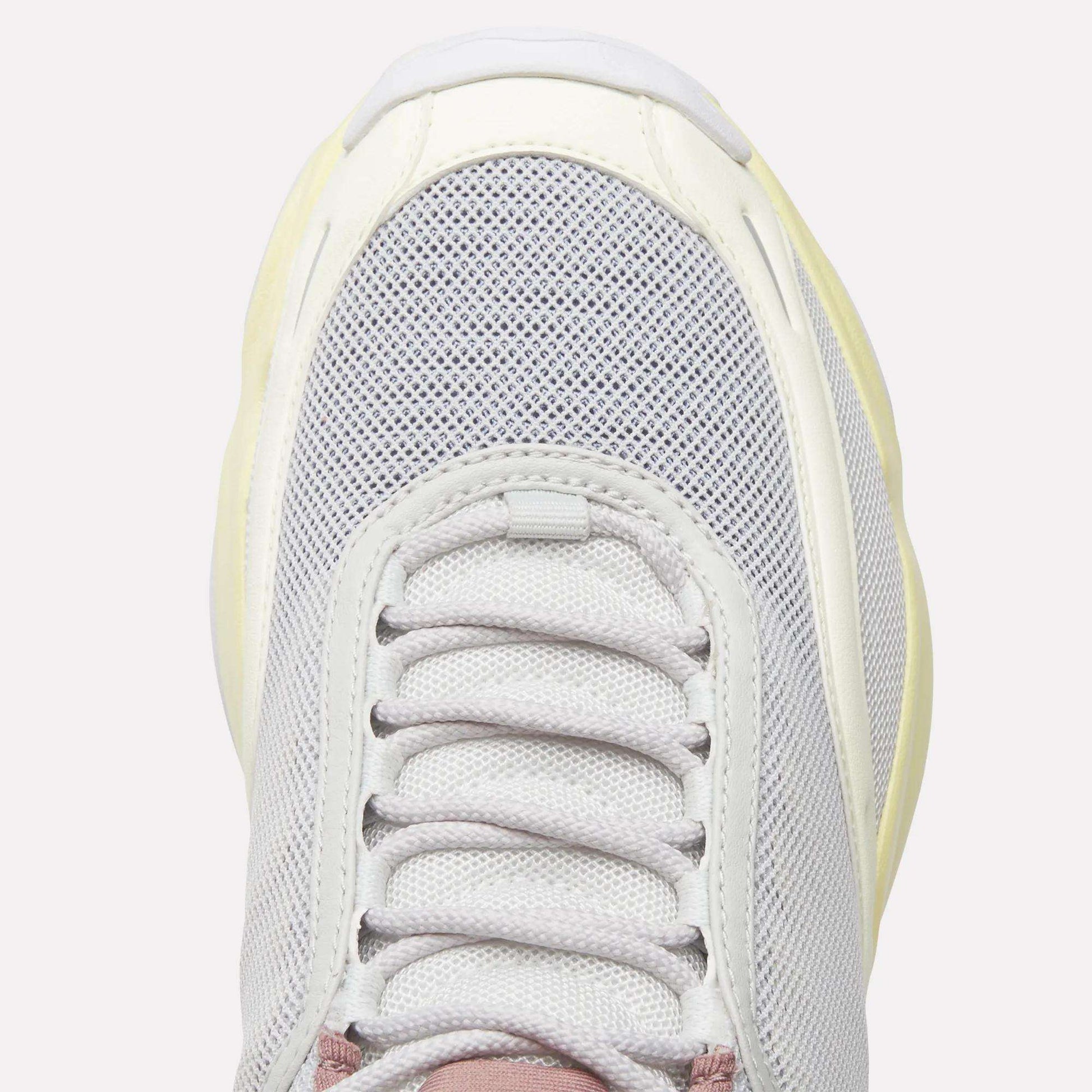 A close-up top view of the Reebok Women's DMX Series 3000 Training Shoe displays its light gray mesh upper, white laces, and cream-colored sole equipped with DMX 3 Technology for advanced cushioning, all set against a plain background.