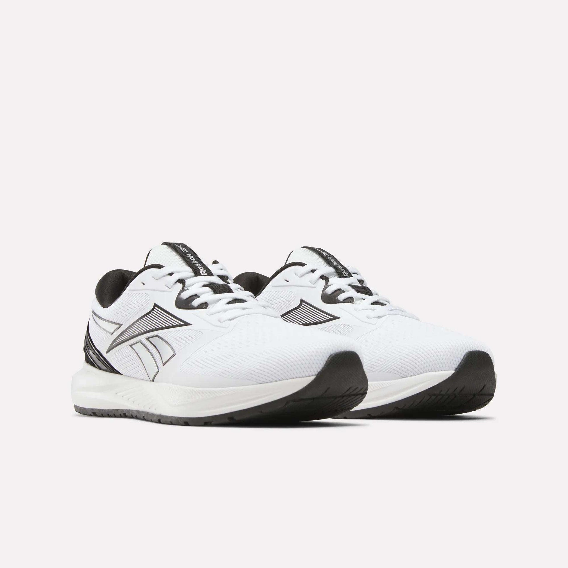 A pair of Reebok Men's Nanoflex 2 Training Shoes in white, highlighted by black accents, breathable mesh uppers, sturdy black soles, and a signature black Reebok logo on the sides—ideal for workouts—displayed against a light background.