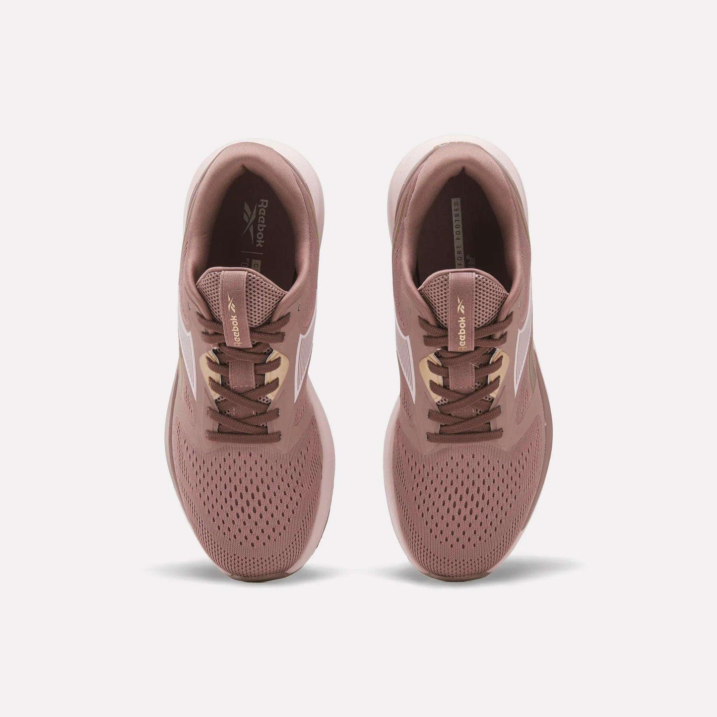 A pair of Reebok Women's Nanoflex 2.0 Training Shoes in pink, shown from above with white side stripes, brown laces, and perforated toes for breathability on a plain white background.