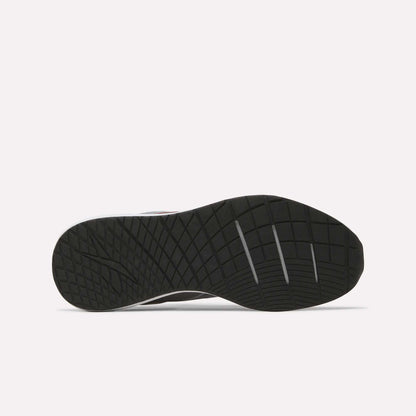 The image displays the black rubber outsole of the Men's Nanoflex 2 Training Shoes by Reebok, featuring a geometric traction pattern and three deep horizontal grooves for enhanced flexibility. The background is plain white.