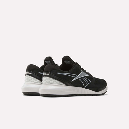 A pair of Women's NFX Trainer 2 Training Shoes by Reebok, featuring black uppers with white soles and silver accents, displayed from a rear side angle on a plain white background.