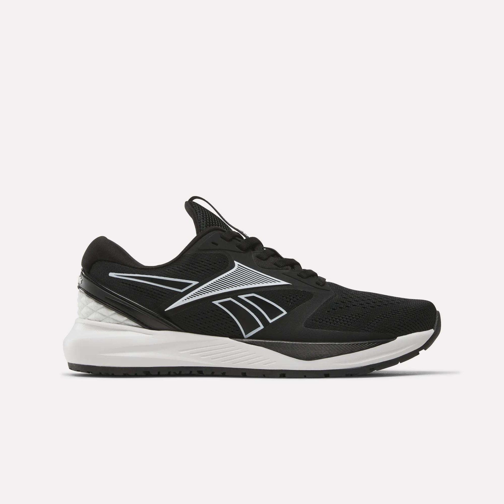 The Women's NFX Trainer 2 Training Shoes by Reebok are black athletic sneakers with white and gray accents, featuring a mesh upper and a white midsole. Designed as versatile workout shoes, they showcase a sleek silhouette with a prominent Reebok logo on the side and are displayed against a plain white background.