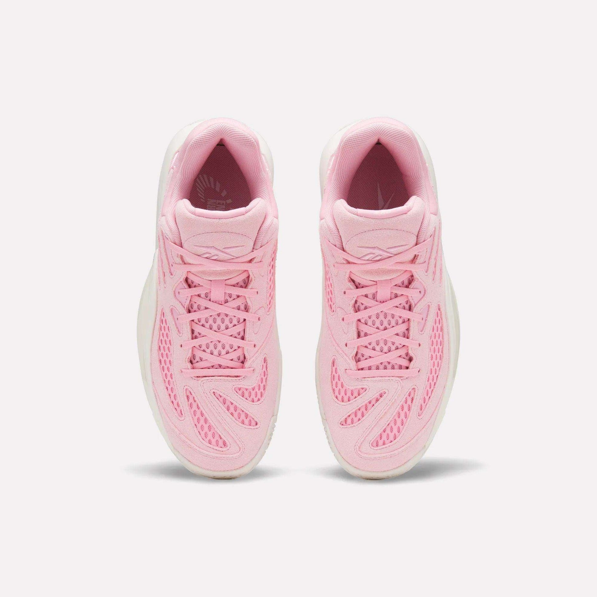 The Reebok Engine A 26 Basketball Shoes are shown from above in pink with mesh, wavy overlays, and white soles. Pink laces match the energetic vibe of these stable sneakers, designed for basketball performance on a white background.