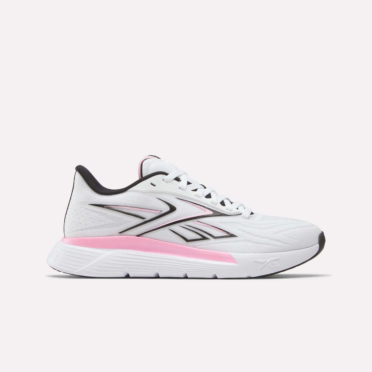 Side view of the Reebok Women's Nano Gym 2.0 Training Shoes in White/Black, showing a lace-up design and low-cut profile with black accents. The midsole features a pink gradient, while the outsole stays mostly white.