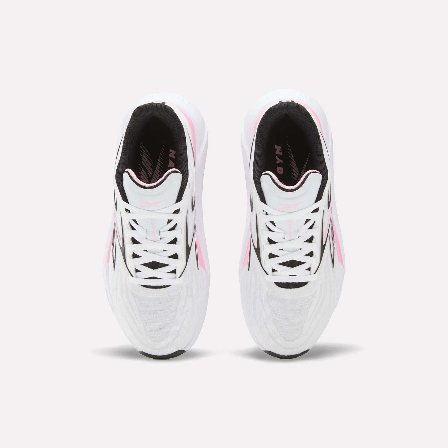 A top view of Reebok Women's Nano Gym 2.0 Training Shoes in white with pink and black accents, shown side by side on a light background, highlighting their laces and stylish design.