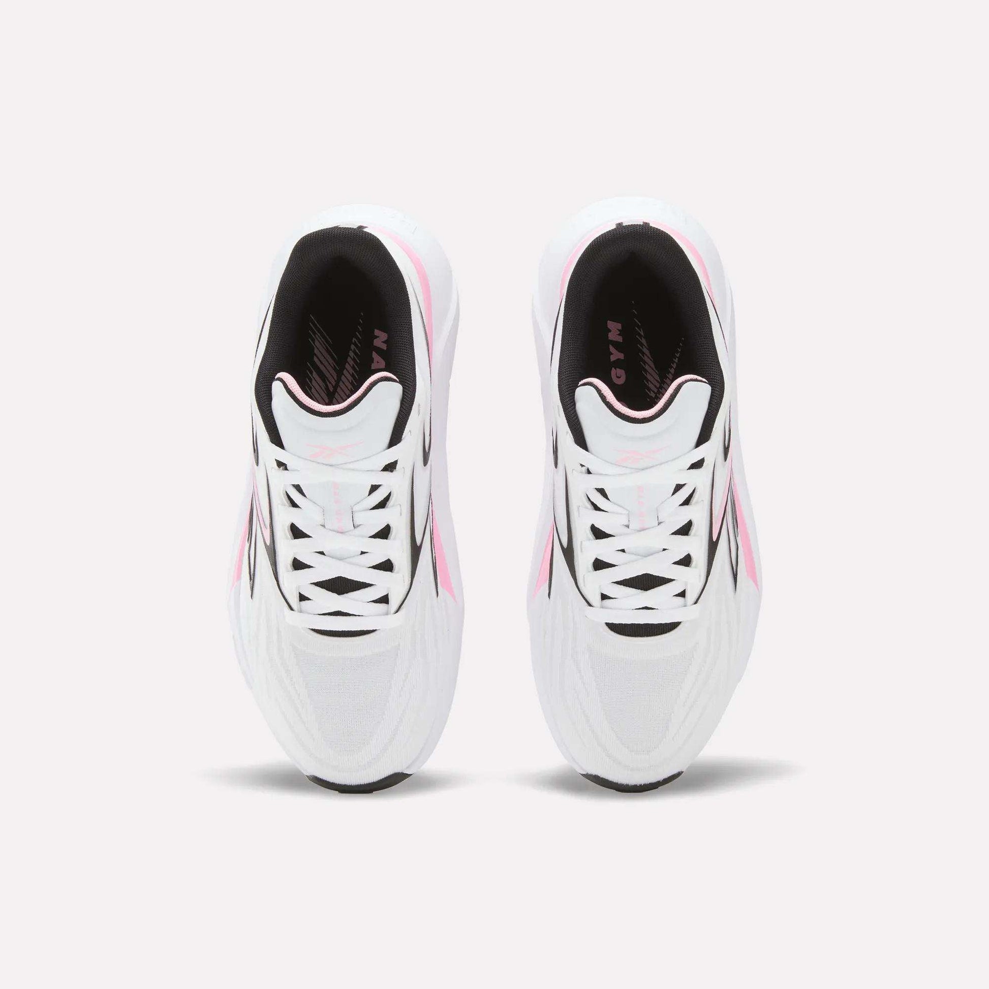 A top view of Reebok Women's Nano Gym 2.0 Training Shoes in white with pink and black accents, shown side by side on a light background, highlighting their laces and stylish design.