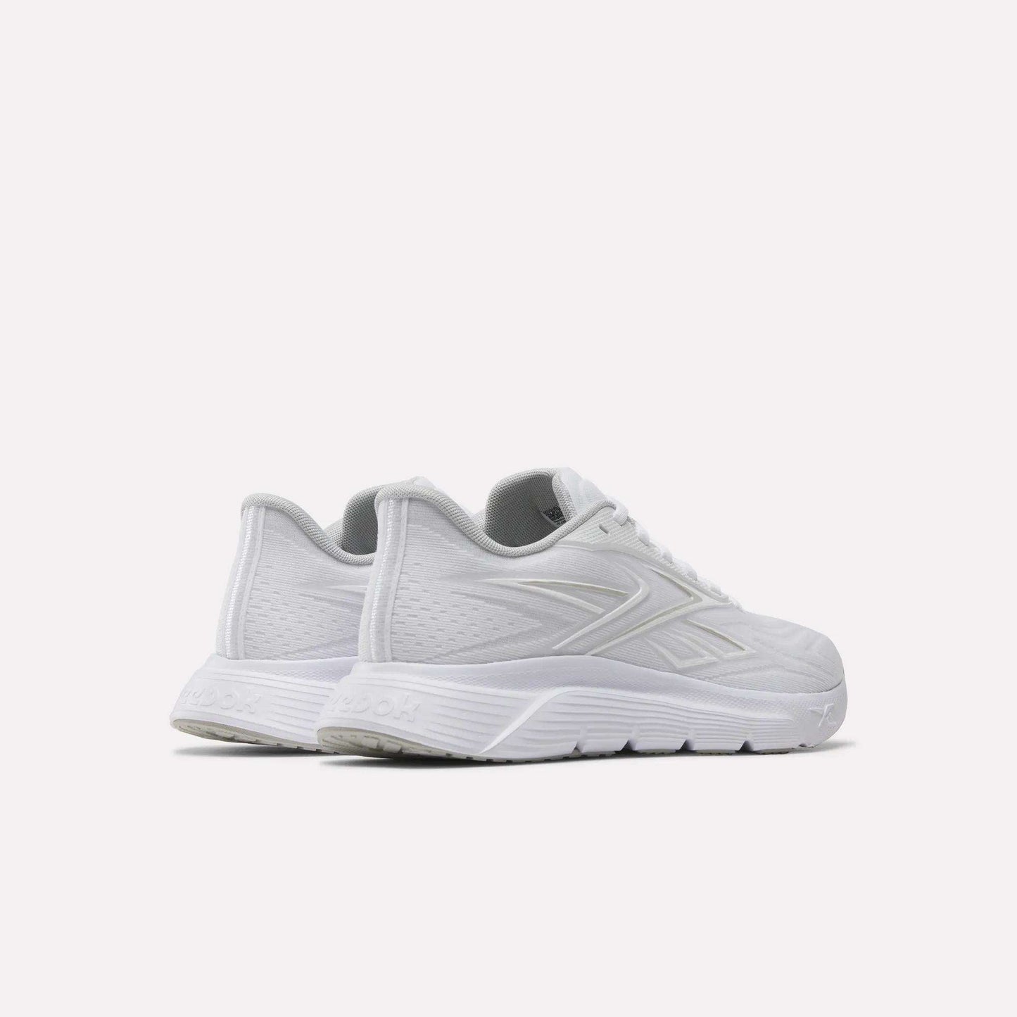 A pair of Reebok Women's Nano Gym 2.0 Training Shoes in white, featuring subtle textured patterns and a grey interior, displayed side by side on a light background from back and side views—ideal for your next workout.
