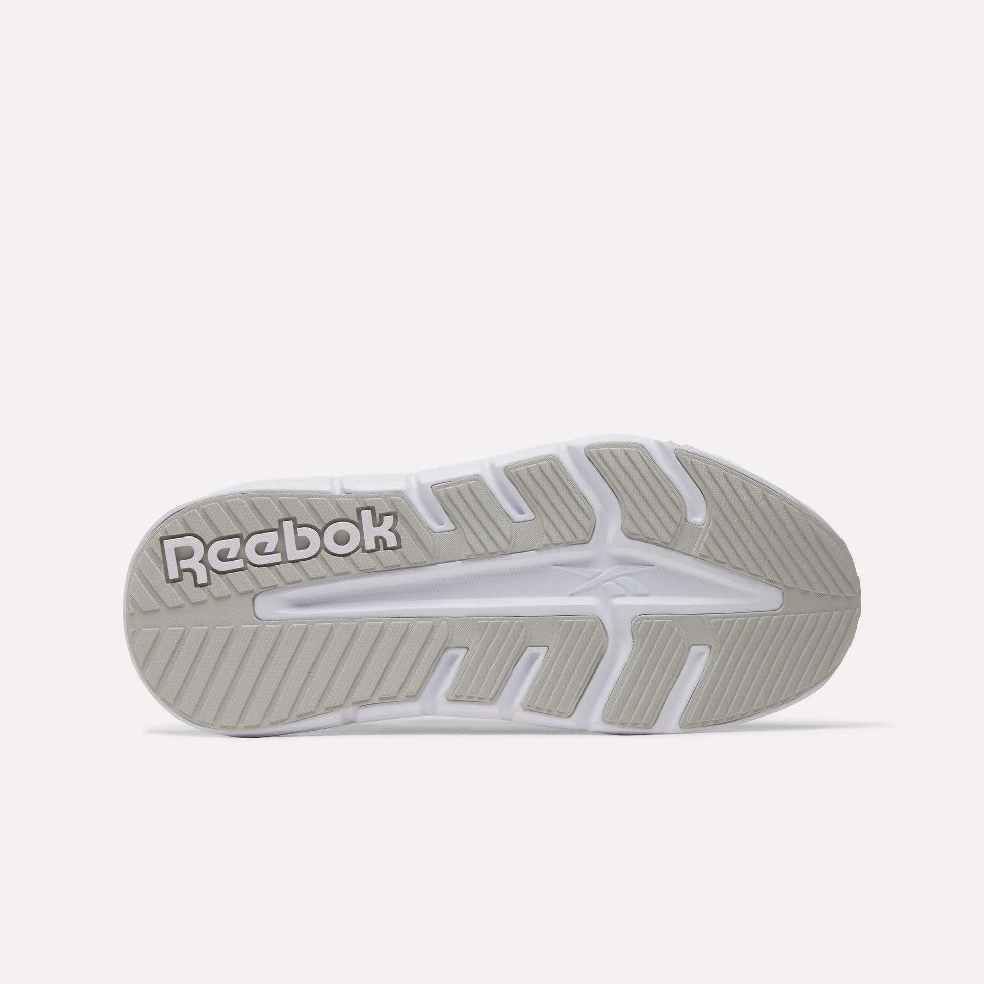 The image shows the underside of a white Reebok sole with light gray tread and "Reebok" in raised letters, emphasizing the durability of the Women's Nano Gym 2.0 Training Shoes.