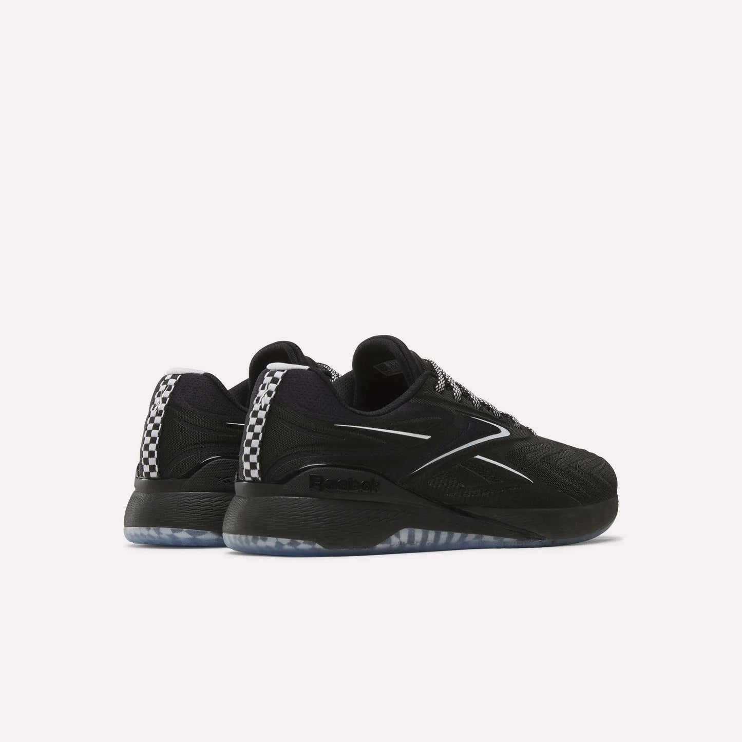 A pair of Reebok Nano X5 Edge Training Shoes in black with white accents, checkered rear pattern, and translucent soles are displayed from an angled rear view on a plain white background for a performance-ready look.