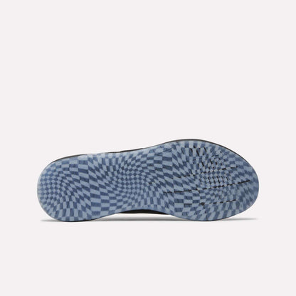 The image shows the sole of a Nano X5 Edge Training Shoe by Reebok, featuring a blue and white checkered pattern with an optical illusion effect. Designed for performance, these stylish training shoes display the Reebok logo near the middle.