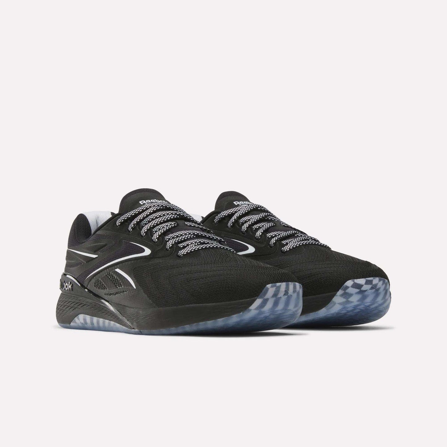 A pair of Reebok Nano X5 Edge Training Shoes in black with white and gray details, patterned black-and-white laces, Flexweave uppers, and translucent gray rubber soles, shown against a plain white background.