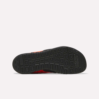 The image displays the bottom view of a black rubber sole from Reebok Men's Nano 2.0 Training Shoes, showing a geometric tread pattern against a plain, light-colored background.