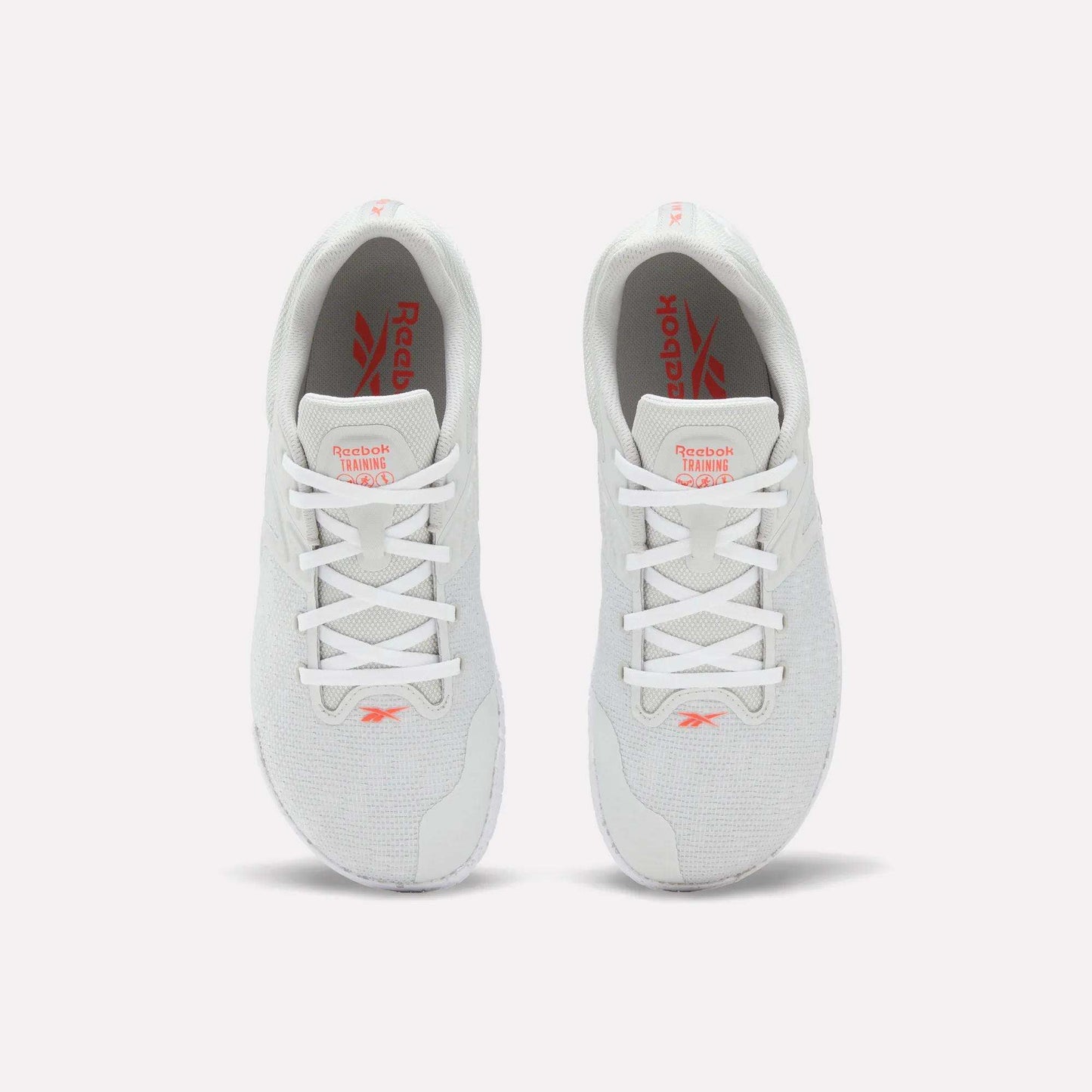 A pair of white Reebok Nano Zero Training Shoes, shown from above on a plain white background, feature red Reebok branding on the tongue and insole, white laces, a breathable mesh upper, and a zero-drop design.