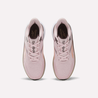 A pair of Women's Viva Speed Shoes by Reebok in light pink, shown from above, featuring white soles, pink laces, and the Reebok logo on the insoles. These breathable shoes provide both comfort and style for athletic activities.