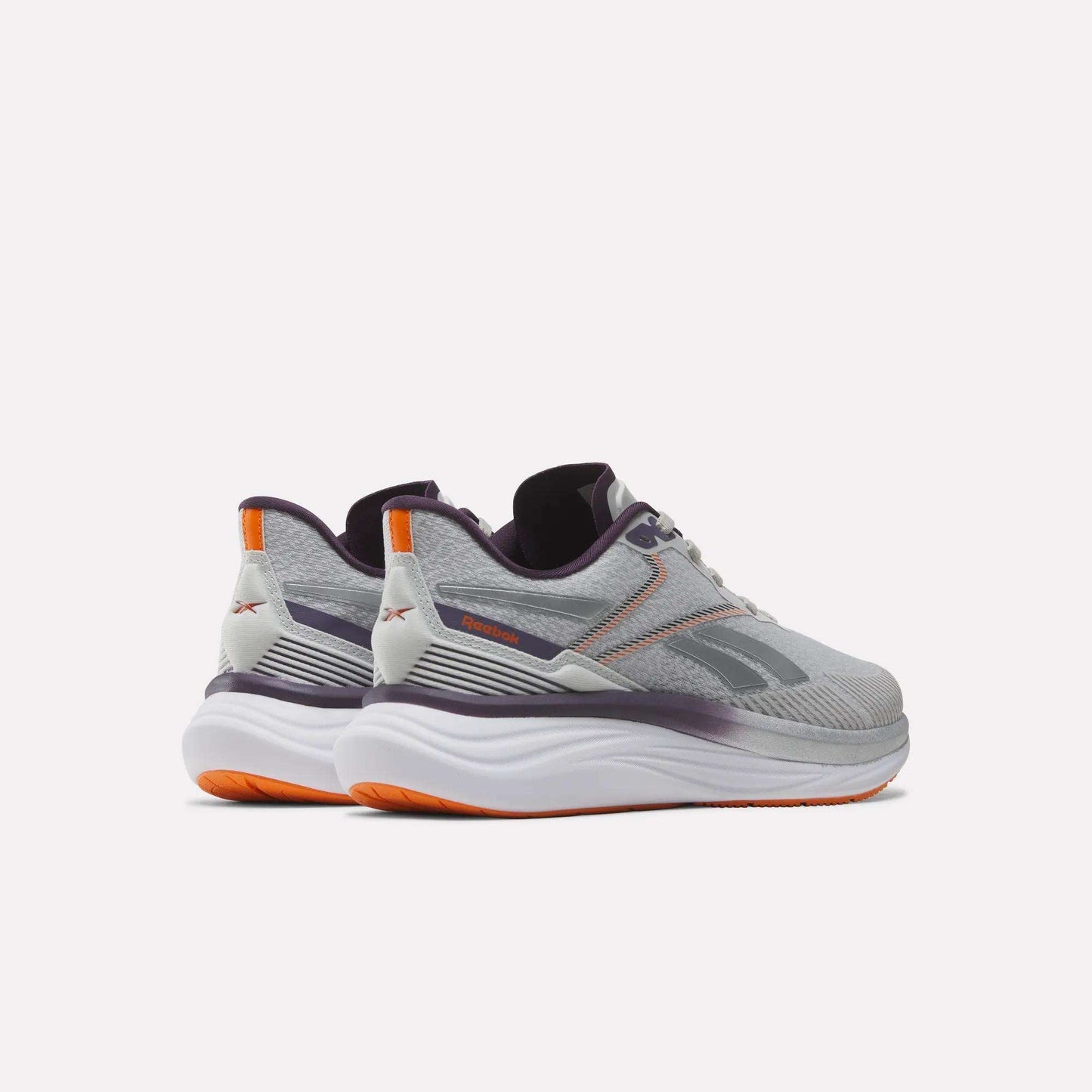 A pair of Women's Viva Speed Shoes by Reebok in gray and white, featuring purple and orange accents, designed with cushioning for enhanced comfort, shown from the back and side against a plain white background.