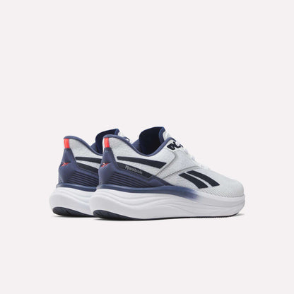 A pair of Reebok Men's Viva Speed Shoes in white with navy blue and red accents, displayed from a rear side angle on a plain white background. These cushioned running shoes are crafted for comfort and style, making them ideal for everyday wear.