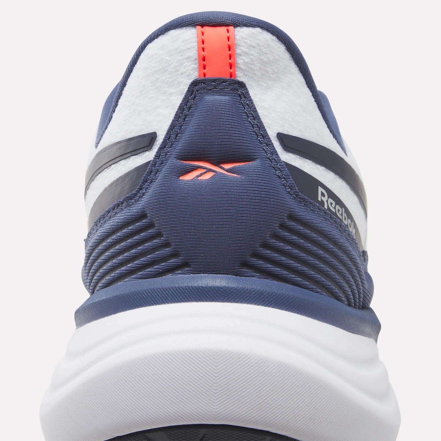 Close-up of the heel of a navy and white Reebok Men's Viva Speed Shoe, showcasing a red logo and red pull tab with textured and striped design details. These cushioned Men's Viva Speed Shoes provide both comfort and style.
