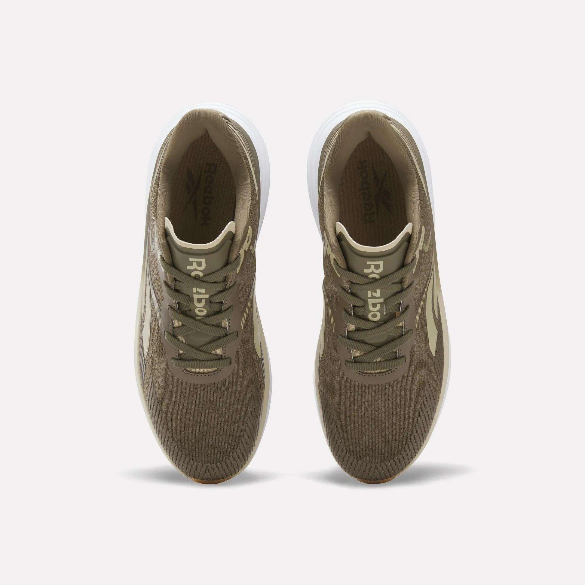 Top view of a pair of Reebok Men's Viva Speed Shoes in brown, featuring white soles, beige laces, and the Reebok logo on both the insoles and tongue, displayed side by side on a white background. These cushioned sneakers deliver style and comfort for everyday wear.