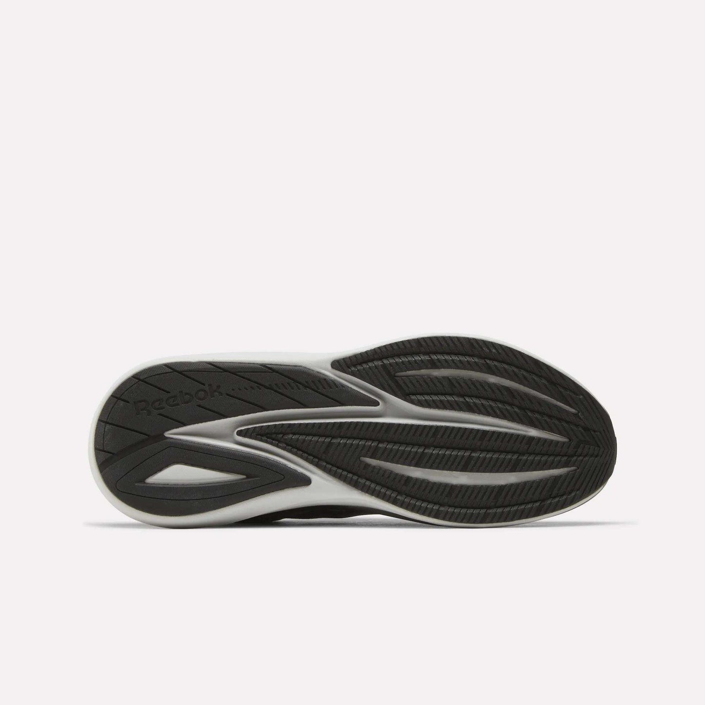 A black and white athletic shoe sole with a textured, wavy tread pattern and the Reebok logo visible on the left side. Designed for comfort, the Men’s Viva Speed Shoes by Reebok feature cushioned sneakers technology. The background is plain white.