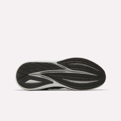A black and white athletic shoe sole with a textured, wavy tread pattern and the Reebok logo visible on the left side. Designed for comfort, the Men’s Viva Speed Shoes by Reebok feature cushioned sneakers technology. The background is plain white.