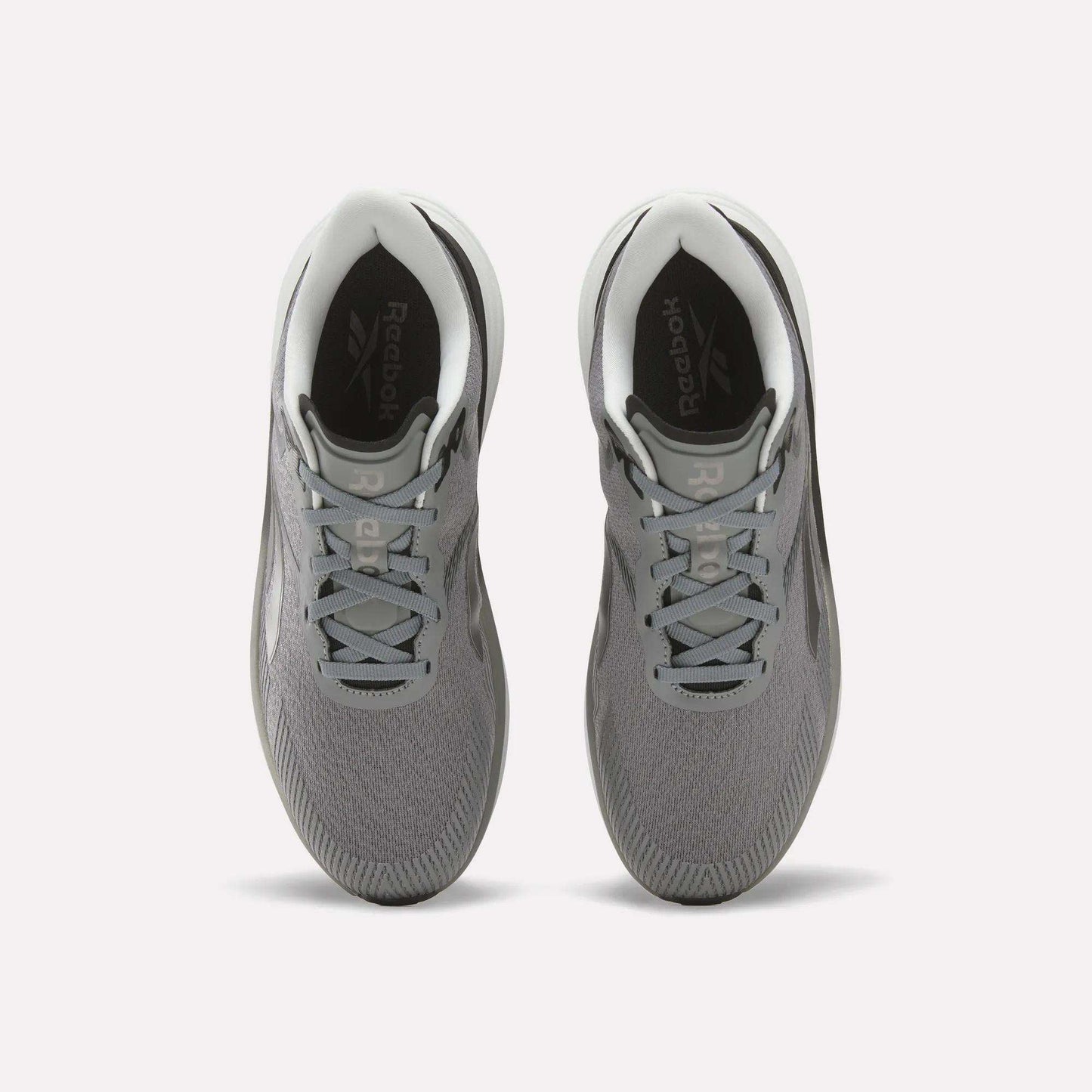 Top view of a pair of Reebok Men's Viva Speed Shoes in gray with white soles and light gray laces on a white background, featuring a breathable design and cushioned comfort for all-day wear.