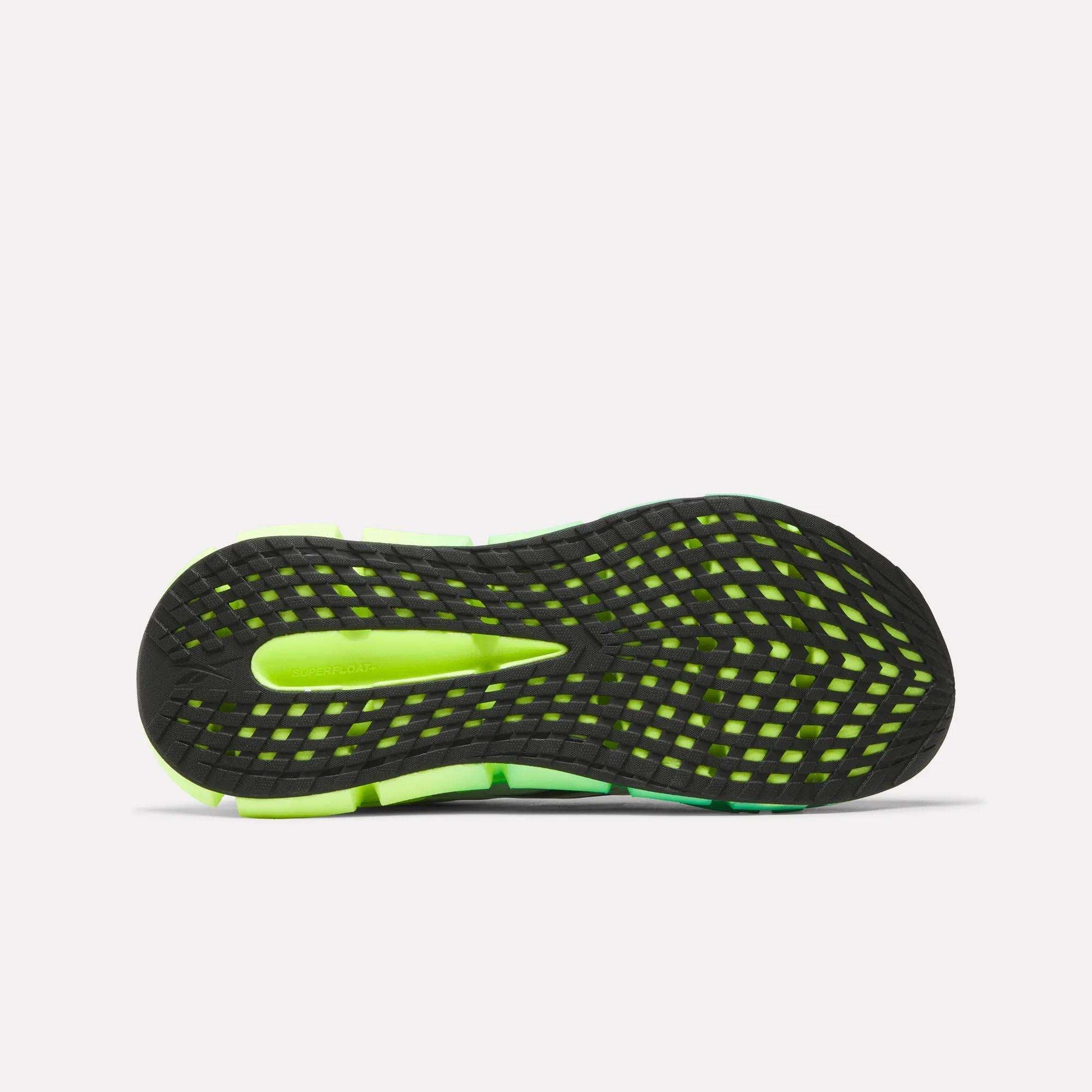 The image shows the bottom view of Reebok Men's FloatZig 2 Running Shoes, featuring a black and neon green sole with a grid-like tread pattern for traction and Superfloat+ cushioning for comfort.