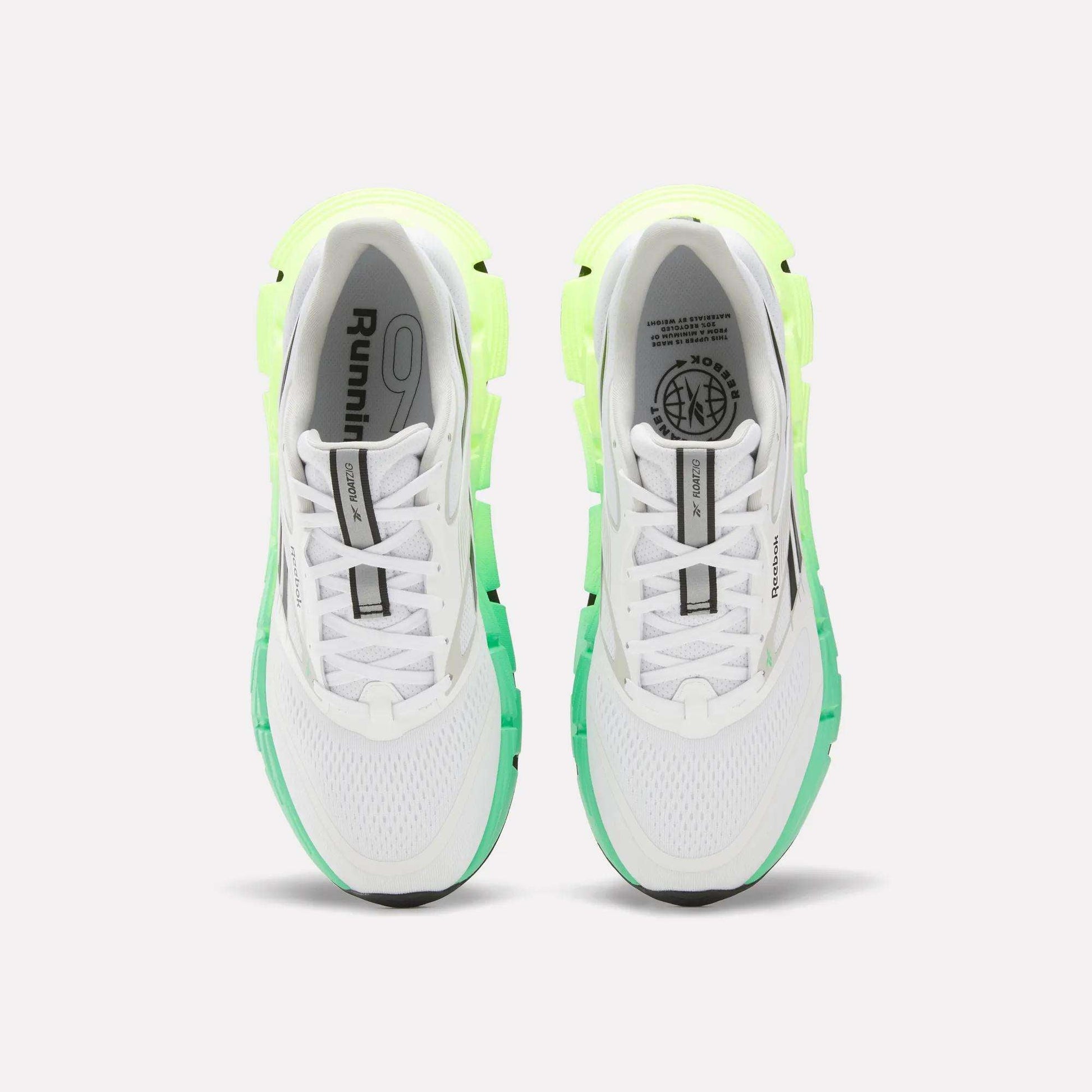A top view of Reebok Men's FloatZig 2 Running Shoes in white with light green and neon yellow accents, Superfloat+ cushioning, black soles, and branding on the tongues and insoles, set against a plain white background.