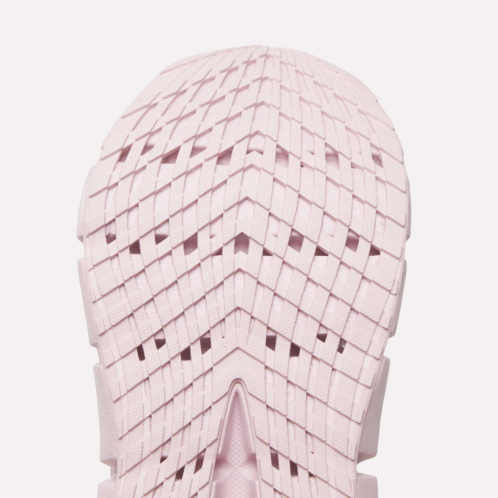Close-up of a light pink Reebok Women's FloatZig 2 Running Shoe sole, featuring a geometric grid tread with chevron shapes and intersecting lines. The symmetrical design showcases Superfloat+ cushioning for a springy run.