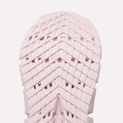 Close-up of a light pink Reebok Women's FloatZig 2 Running Shoe sole, featuring a geometric grid tread with chevron shapes and intersecting lines. The symmetrical design showcases Superfloat+ cushioning for a springy run.