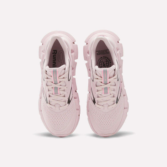 A pair of Women's FloatZig 2 Running Shoes by Reebok in light pink, seen from above with mesh uppers, chunky soles with Superfloat+ cushioning, and light blue and pink striped laces, displayed on a white background.