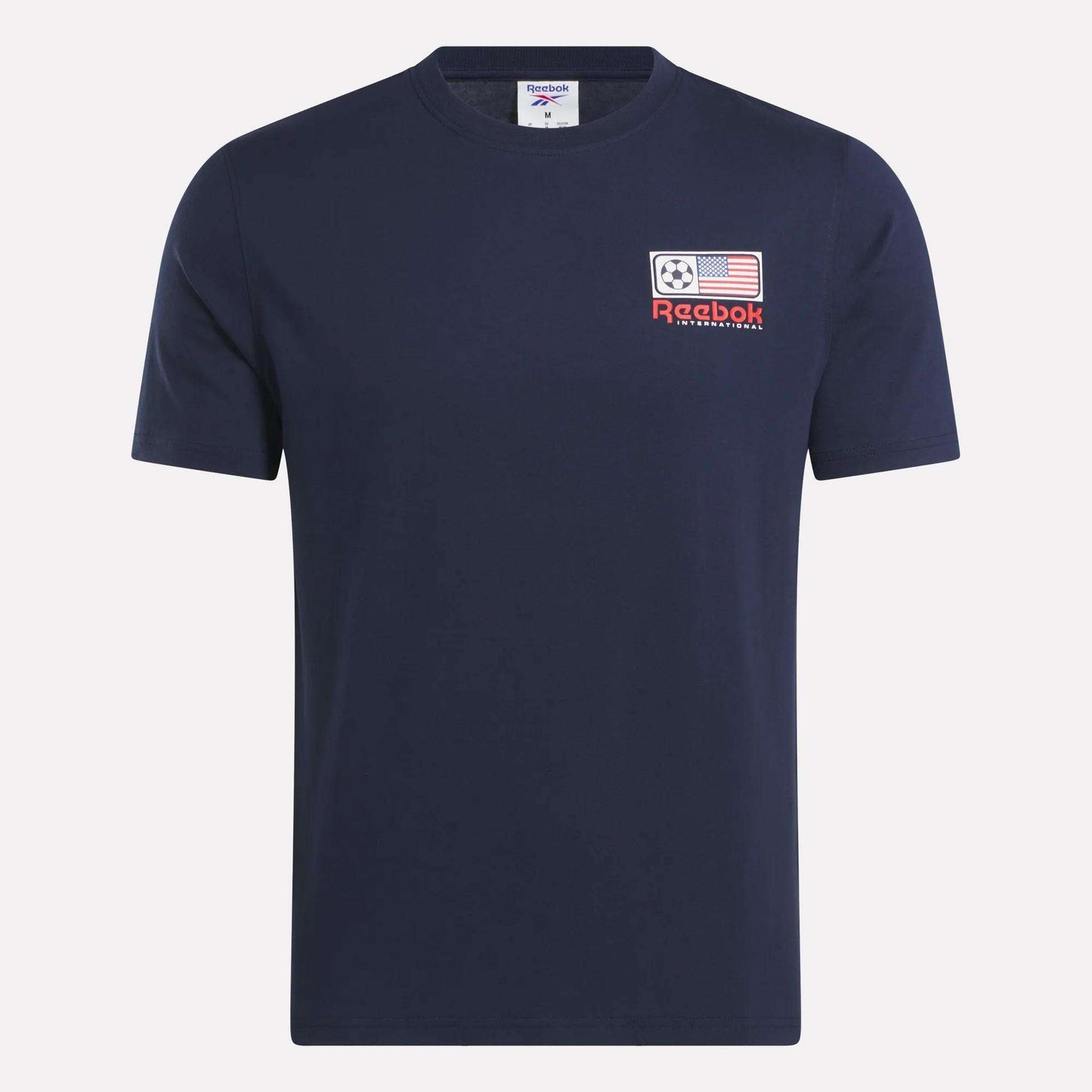 The Reebok USA Football T-Shirt is a navy blue, short-sleeve cotton jersey with a left chest patch featuring a soccer ball, American flag, red Reebok logo, and "International" text.