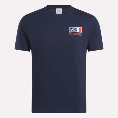 The Reebok France Football T-Shirt is a navy blue short-sleeve tee with a left chest patch featuring a football, the French flag, and "Reebok International" text—ideal for soccer fans.