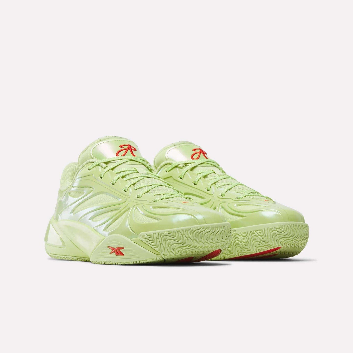 The Reebok Angel Reese 1 Basketball Shoes, in lime green with shiny textured surfaces, red logo accents, and a chunky sole featuring the Energy Return System, are displayed against a plain white background.