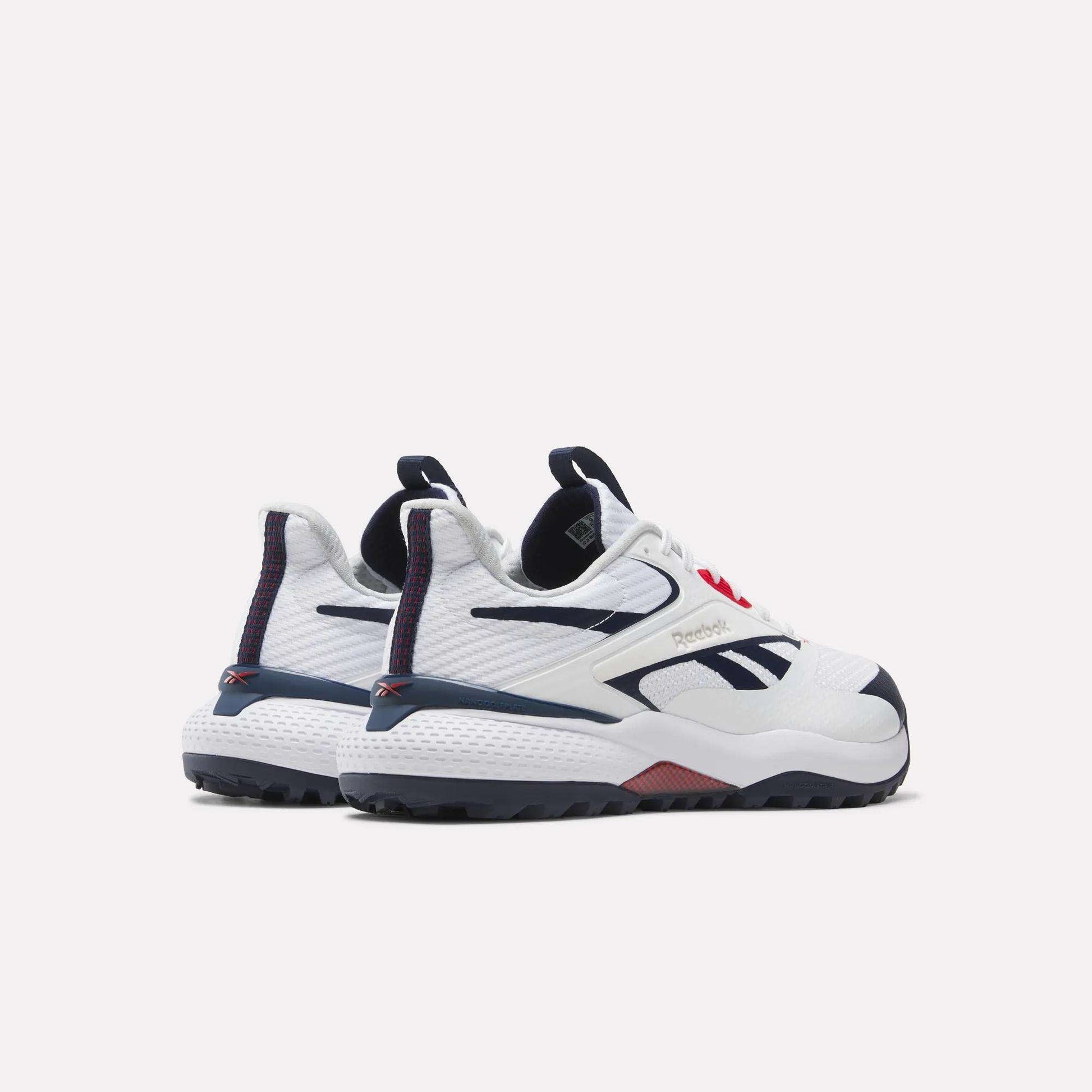 A pair of Reebok Nano Golf Shoes in white with dark blue and red accents, featuring a FlexWeave upper, shown from the back and side against a plain light background.