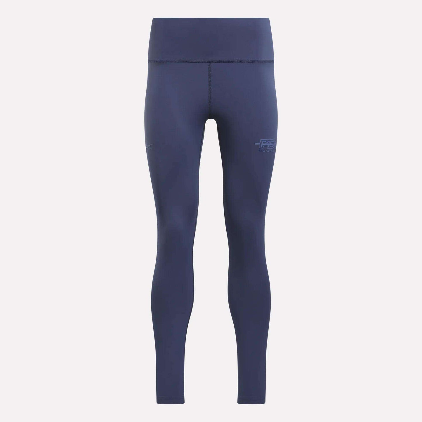 The Women's Reebok x F45 Training Leggings by Reebok are navy blue, high-waisted athletic leggings with a supportive high-rise waistband and a seamless design. They feature visible stitching and a small F45 logo on the left thigh, and are displayed against a plain light background.