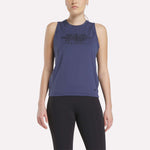 A woman wears the Women's Reebok x F45 Training Tank Top in navy and black leggings, standing facing forward against a plain white background.