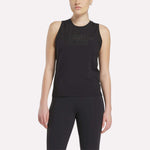 A woman stands with arms relaxed by her sides, wearing a sleeveless black Reebok x F45 Training Tank Top and black leggings. The sweat-wicking top is perfect for high-intensity workouts, shown against a plain light background.