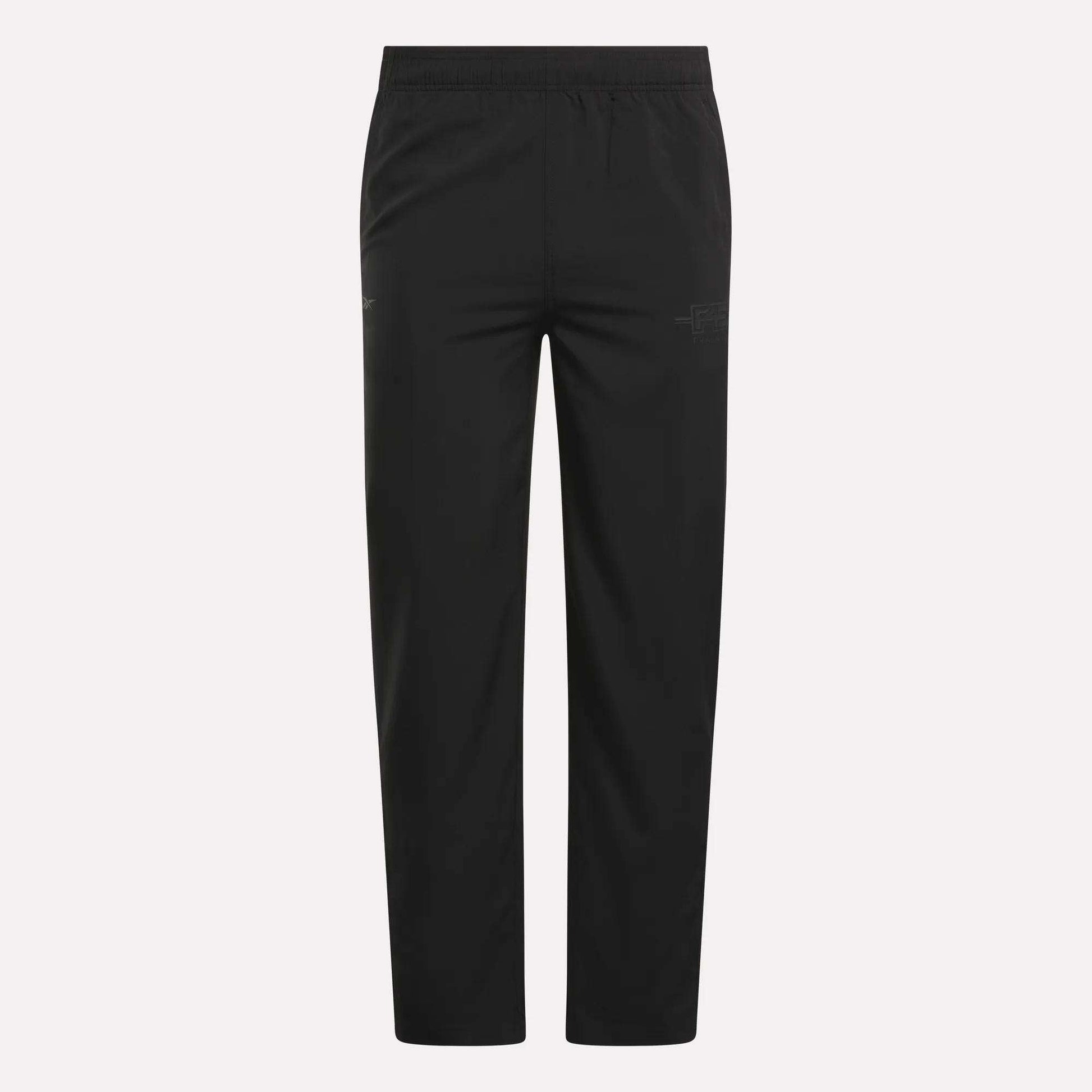 The Men's Reebok x F45 Training Woven Pants feature an elastic waistband, straight legs, and subtle stitching details, designed by Reebok for optimal performance during high-intensity training sessions. They are shown against a plain white background.