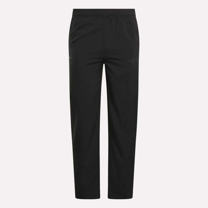 The Men's Reebok x F45 Training Woven Pants feature an elastic waistband, straight legs, and subtle stitching details, designed by Reebok for optimal performance during high-intensity training sessions. They are shown against a plain white background.