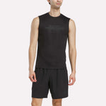 A person wearing the Men's Reebok x F45 Training Tank Top in black stands against a plain light background, ready for high-intensity training.