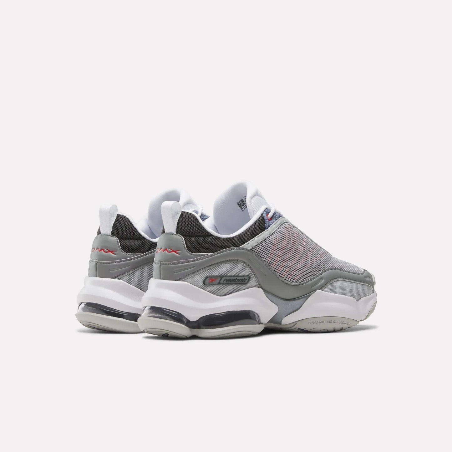 A pair of gray and white Reebok DMX Series 3000 Shoes with mesh uppers, thick white soles, and visible air cushioning are viewed from the back and side against a plain white background, combining classic comfort.