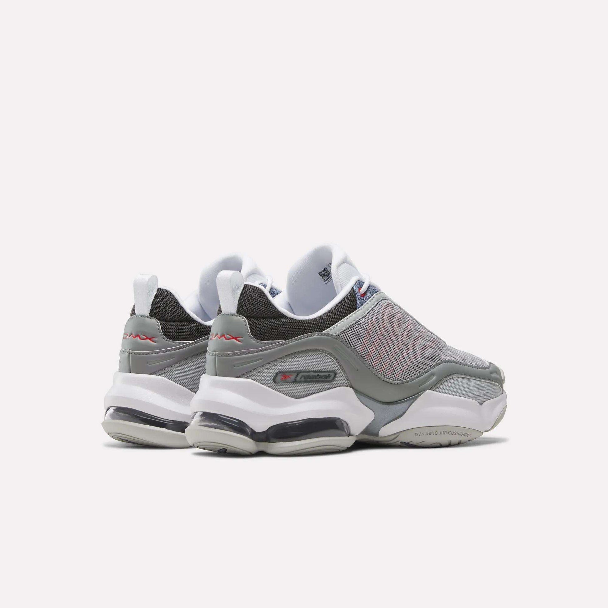 A pair of gray and white Reebok DMX Series 3000 Shoes with mesh uppers, thick white soles, and visible air cushioning are viewed from the back and side against a plain white background, combining classic comfort.