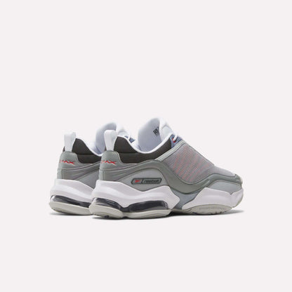 A pair of gray and white Reebok DMX Series 3000 Shoes with mesh uppers, thick white soles, and visible air cushioning are viewed from the back and side against a plain white background, combining classic comfort.