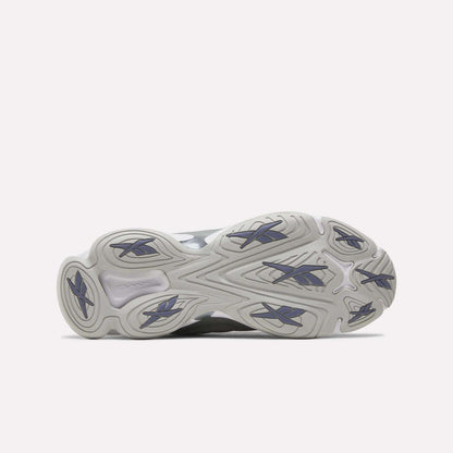 The image displays the outsole of the Reebok DMX Series 3000 Shoes, showcasing a wavy, textured light gray pattern with dark blue rubber traction accents against a white background. These shoes are engineered for comfort and enhanced grip, featuring innovative DMX moving air technology.