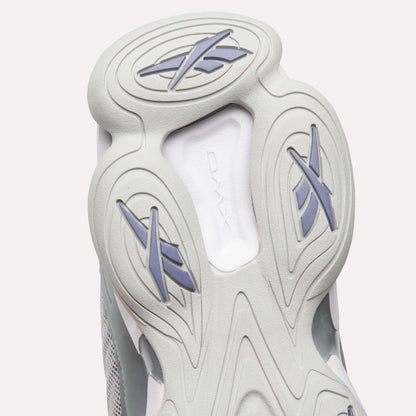 Close-up of the sole of the Reebok DMX Series 3000 Shoes, highlighting light gray and white hues with distinctive oval patterns and stylized X shapes in blue and gray rubber—demonstrating the signature comfort of Reebok footwear with DMX moving air technology.