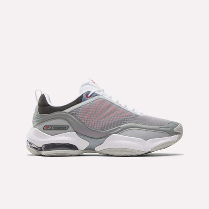 The Reebok DMX Series 3000 Shoes in Grey/White/Red feature mesh panels, white laces, a visible air-cushioned sole with DMX moving air technology for enhanced comfort, and subtle red accents. They are displayed on a plain white background.