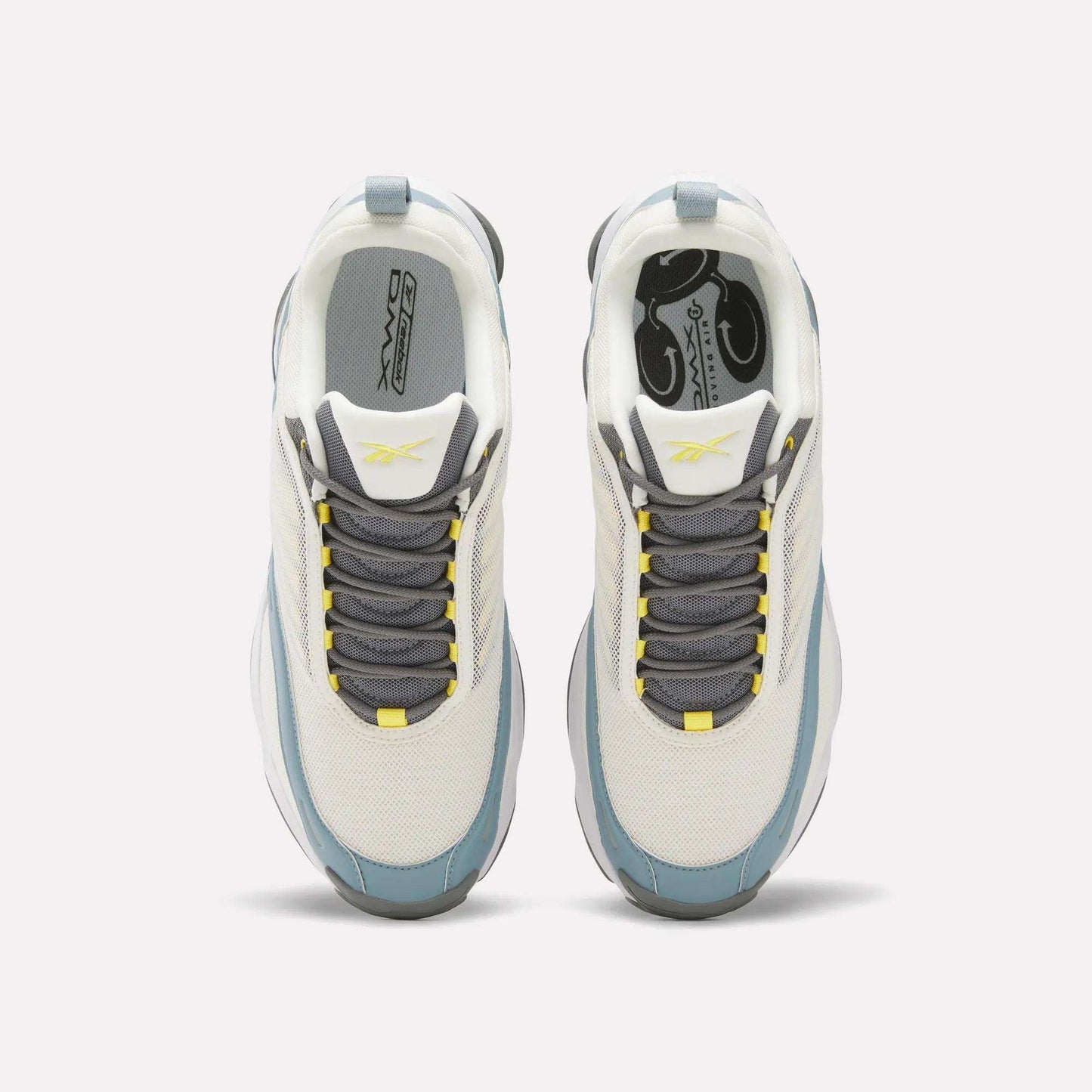 Top view of white Reebok DMX Series 3000 Shoes with gray and blue accents, gray laces, and yellow details on the tongue and lace holes. Designed for comfort with DMX moving air technology, shown on a plain light background.