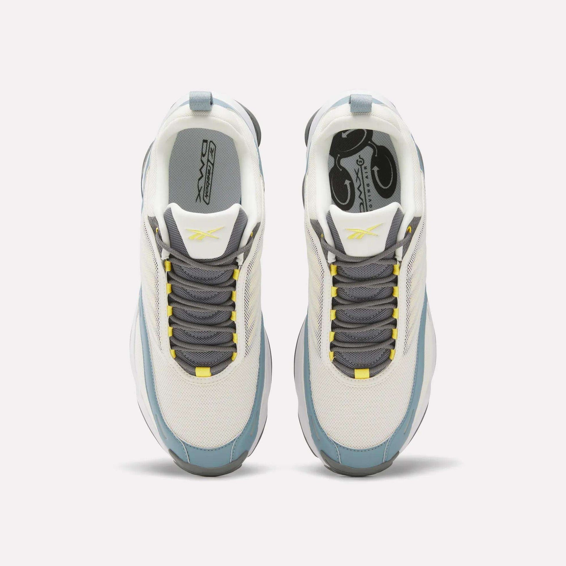 Top view of white Reebok DMX Series 3000 Shoes with gray and blue accents, gray laces, and yellow details on the tongue and lace holes. Designed for comfort with DMX moving air technology, shown on a plain light background.