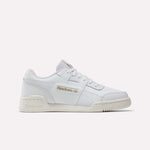 The Reebok Workout Plus Shoes - Big Kids are white low-top sneakers with gold branding on the side and heel, white laces, and an off-white sole—ideal sporty footwear for juniors, shown on a plain white background.