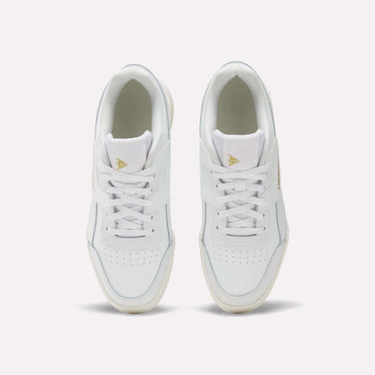 A pair of Reebok Workout Plus Shoes for big kids with laces, seen from above on a light background. These sporty white sneakers have perforated toe boxes and gold triangle logos on the tongues—ideal for juniors who want style and comfort.